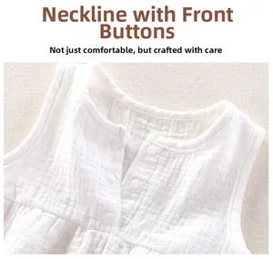 Detail of baby cotton gauze top with round neck and white resin snap buttons