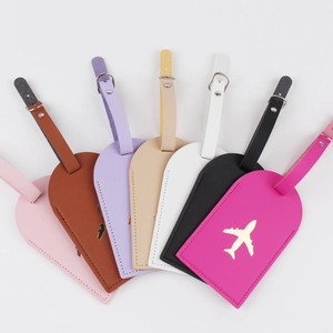 Group of colorful heart-shaped leather luggage tags featuring golden airplane motifs
