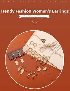 Detail of 18K gold plated stainless steel earring set with sun, moon and leaf charms