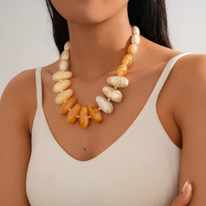 Close-up of chunky acrylic geometric necklace with amber gradient and marble texture