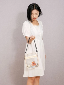 Close-up of transparent PVC crossbody bag showing internal cosmetics and beige trim