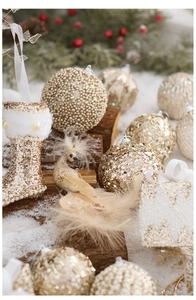 Detailed close-up of champagne gold Christmas ornaments with pearls and glitter details