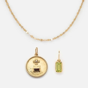 Golden chain necklace featuring a round engraved coin pendant and a green zircon stone