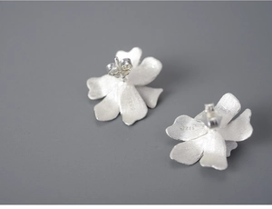 Macro detail of S925 sterling silver petal earrings showing floral texture and hallmark