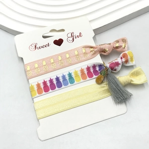 Three-piece elastic hair tie set featuring pineapple prints and tassel on display card