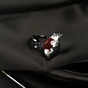 Macro view of butterfly ring with enamel wings and gems on black silk background