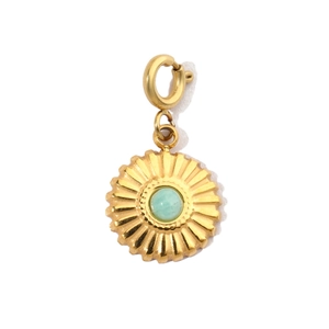 Detail of a vintage golden sunburst pendant with light green stone and integrated clasp