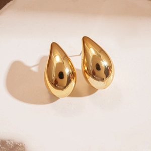 Close-up of polished golden water drop stud earrings with a minimalist 3D design
