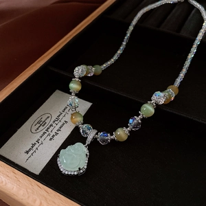 Detailed close-up of zircon Buddha pendant with crystal beads in a jewelry box