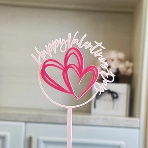 Detail of pink acrylic double heart cake topper with Happy Valentine's Day text