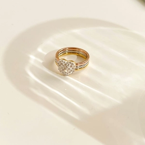 Three-tone intertwined ring featuring a heart-shaped sparkling pavé-set diamond center