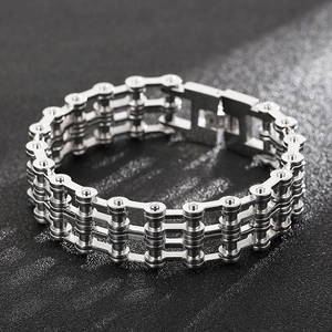 Détail macro du bracelet chaîne de moto triple couche en acier titane argenté sur fond sombre