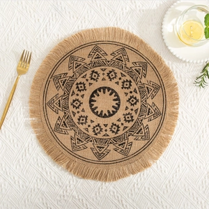 Macro shot of circular jute placemat featuring black geometric patterns and fringe detail