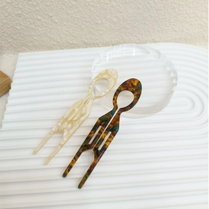 Detail view of acetate U-shaped hair pins in beige marble and tortoise shell patterns