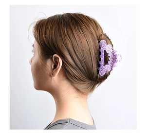 Detail of purple butterfly hair claw clip with rhinestones worn on a stylish updo