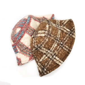 Detailed texture of thick plush plaid bucket hats in red, blue and beige colorways