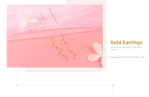 Detail of gold spiral wave earrings on pink silk with floral petals backdrop