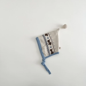 Detailed knit texture of a baby winter hat with puppy pattern and warm earflaps