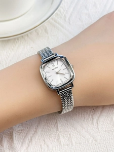 Detail of luxury square silver watch with faceted glass and mesh band on female wrist