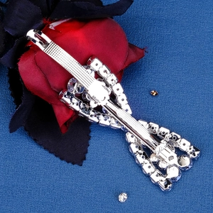 Detail view of silver metal bow hair clip with clear rhinestone inlay and spring clasp
