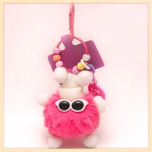 Detailed view of pink plush cat ball keychain with sunglasses and knitted hat detail