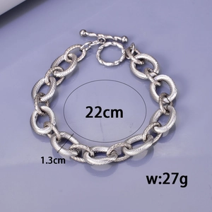 Textured stainless steel thick chain bracelet with OT toggle clasp on purple surface