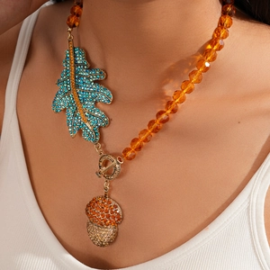 Detail of crystal beads and oversized leaf pendant with acorn drop on a luxury necklace