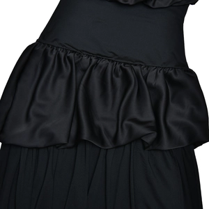 Close-up of black strapless dress featuring ruffled waist detail and draped fabric