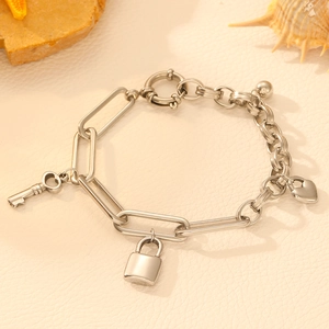 Stainless steel paperclip chain bracelet with silver key, lock, and heart pendants