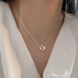 Minimalist silver chain necklace with polished circle and clear bead pendant detail
