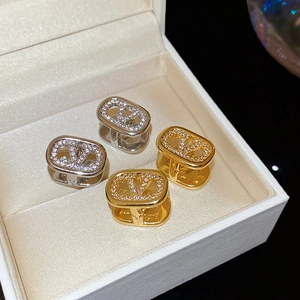 Detailed close-up of 18k gold plated oval V-shaped earrings with sparkling zircon inlay