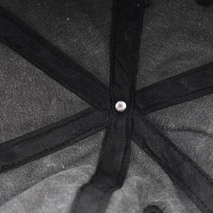 Detail view of reinforced inner seams and metal rivet on washed cotton baseball cap
