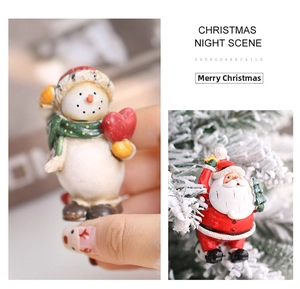 Close-up of miniature resin snowman and Santa Claus ornaments for festive decoration