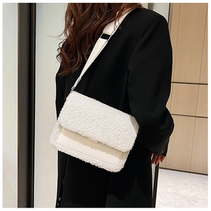 Detail of off-white faux shearling crossbody bag with leather flap and wide strap