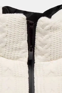 Detailed macro view of white cable knit fabric with a black zipper and inner lining texture