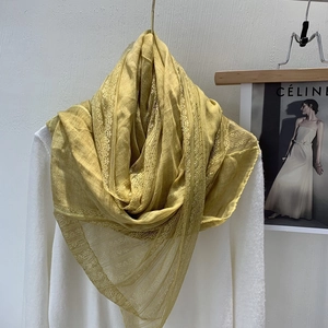 Detail of yellow linen scarf with delicate lace trim on a hanger with magazine