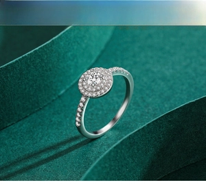 Macro shot of s925 silver double halo ring with round zircon on green textured backdrop