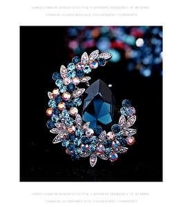 Detail of moon brooch with deep blue teardrop crystal and sparkling rhinestones