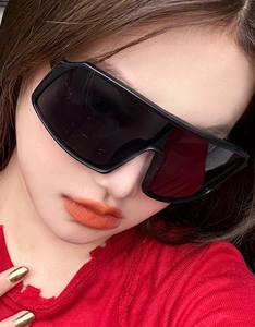Close-up of woman wearing oversized flat top sports cycling sunglasses with black frame