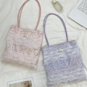 Close-up of pink and purple lace tote bags with shimmering sequins and thin straps