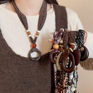 Close-up of printed fabric ethnic necklace with wood beads and oval resin pendant
