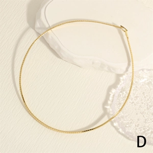 Close-up of 18K gold-plated snake bone chain with square links on white decorative stones