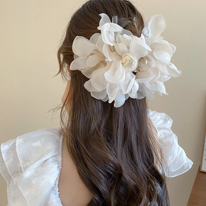 Detail of large white lace flower hair claw with elegant pearl center for women