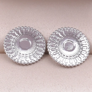 Detailed close-up of 304 stainless steel round earring base components on pink silk