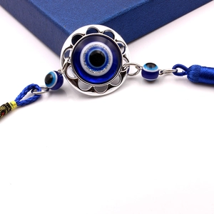 Detailed view of Turkish evil eye ornament with blue tassels and silver hollow base