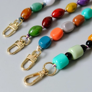 Close-up of colorful handmade resin beaded chains with bright gold lobster clasps