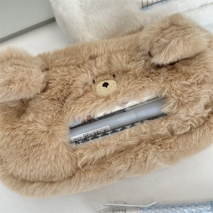 Close-up of cute brown plush bear pencil case showing soft texture and spacious interior