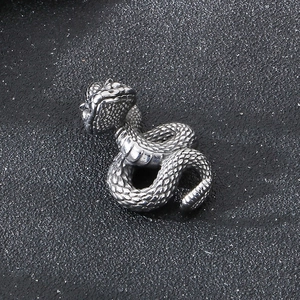 Macro view of a silver punk snake pendant with detailed scales on black background