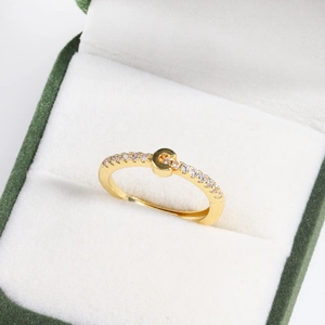 Macro shot of 18k gold plated adjustable ring with sparkling crystal accents in a box