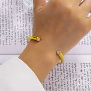 Detail of 18K gold-plated C-shaped cuff bracelet with small pearls and crystals on a wrist
